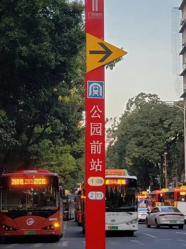 A red Guangzhou Metro street sign on Beijing Road showing a directional arrow, the metro logo, and the station name Gongyuanqian, with numbered bus routes listed below