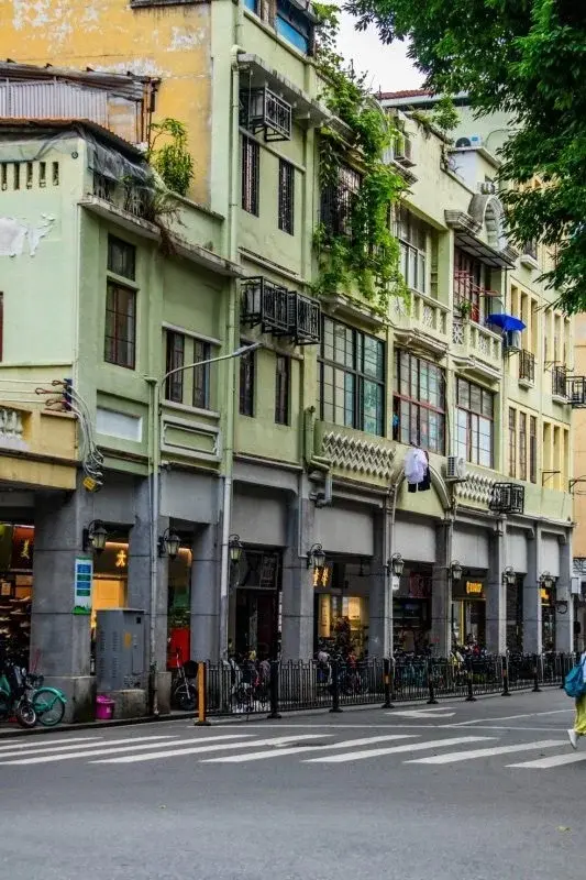 A row of arcade-style qilou buildings in Guangzhou, the upper floors cantilevered over a covered ground-floor walkway supported by square columns
