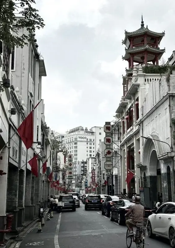A commercial street in Guangzhou at dusk, red lanterns and pagoda-roofed shopfronts lining both sides