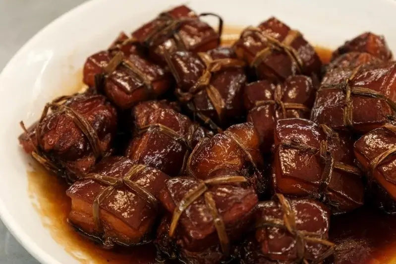 A plate of Dongpo pork, tied squares of braised pork belly glazed in dark soy sauce