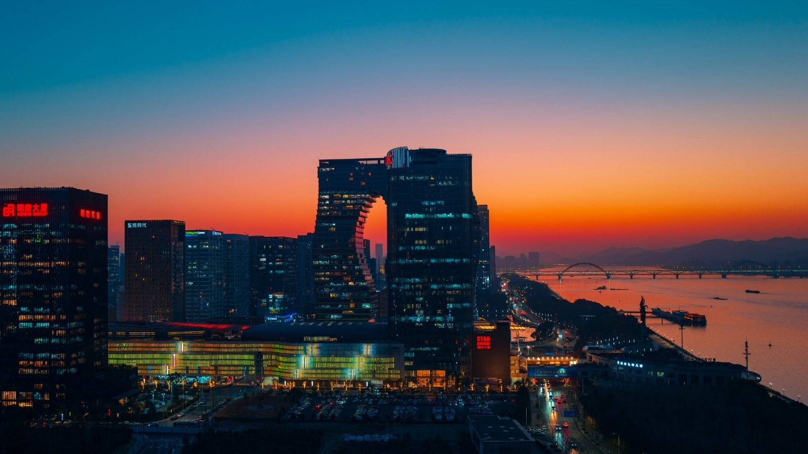 Modern office towers along the Qiantang River in Hangzhou at sunset, part of the city's platform-economy business district