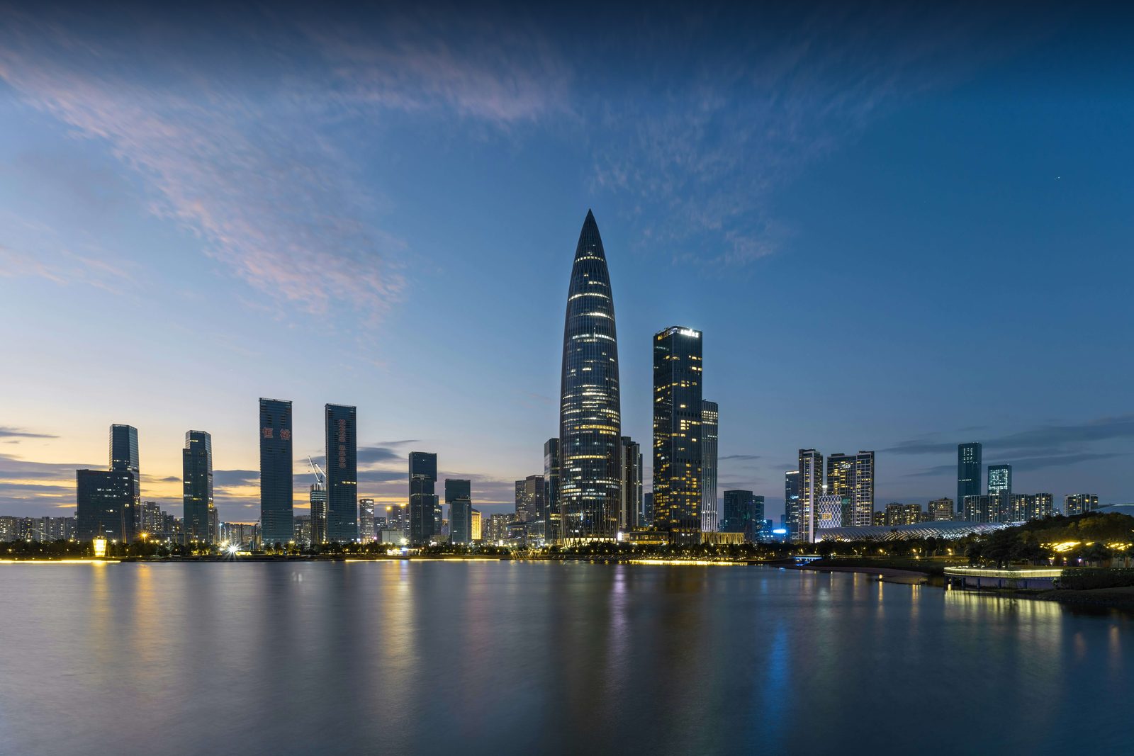 Shenzhen's Nanshan skyline at dusk over Shenzhen Bay, the tapering China Resources Tower at center