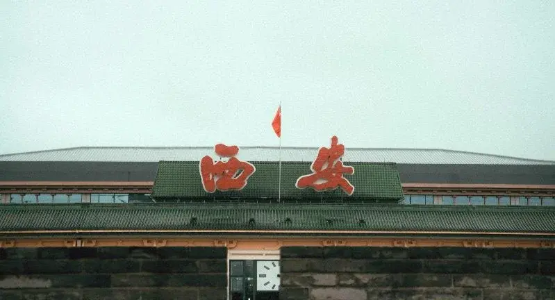 A green-roofed station building with Lintong in large red characters mounted above the entrance