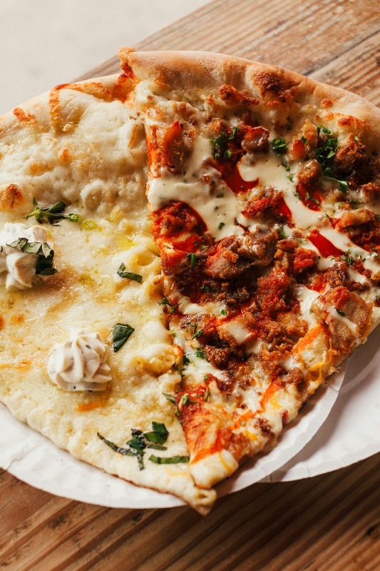 A slice of Chicago deep-dish pizza with a thick, sauce-and-cheese-loaded crust on a paper plate