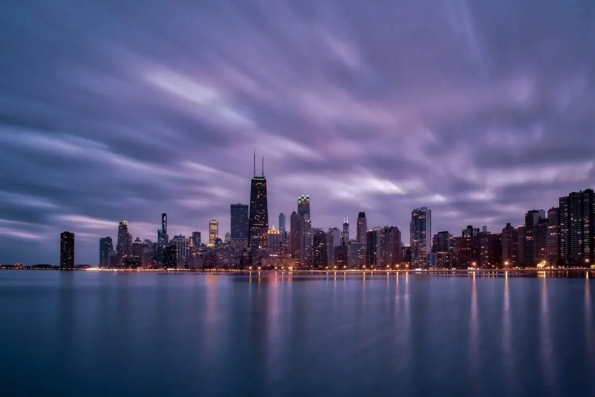 Chicago skyline and the Chicago River at dusk, skyscrapers lit against the evening sky