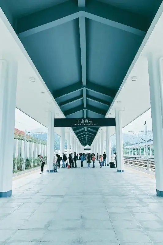 Passengers waiting on the platform at Qiandaohu Railway Station, a bright covered high-speed rail station near Thousand Island Lake