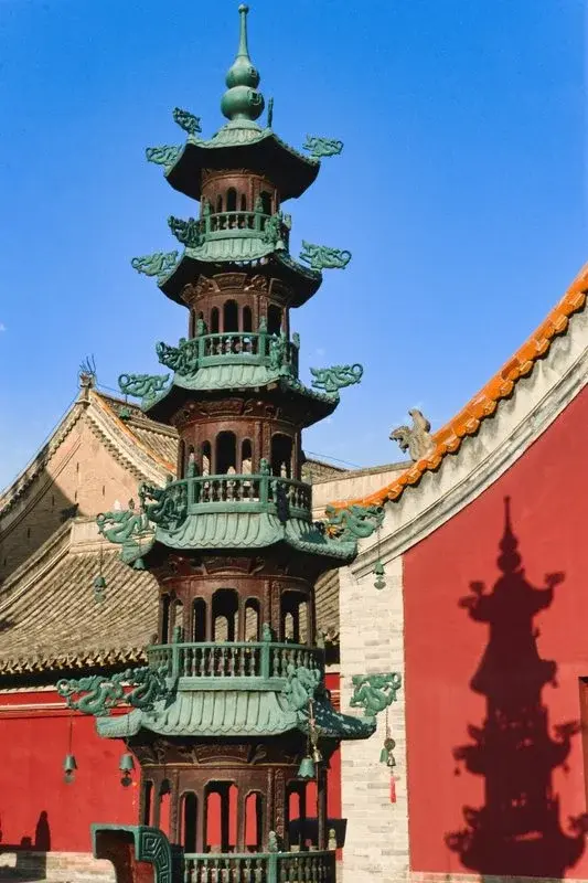 Ornate colorful temple roof detail against a blue sky in Hohhot