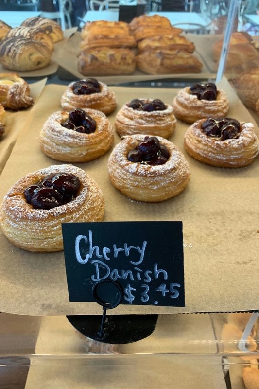 Cherry danishes in a Honolulu bakery display case, priced at $3.45 each