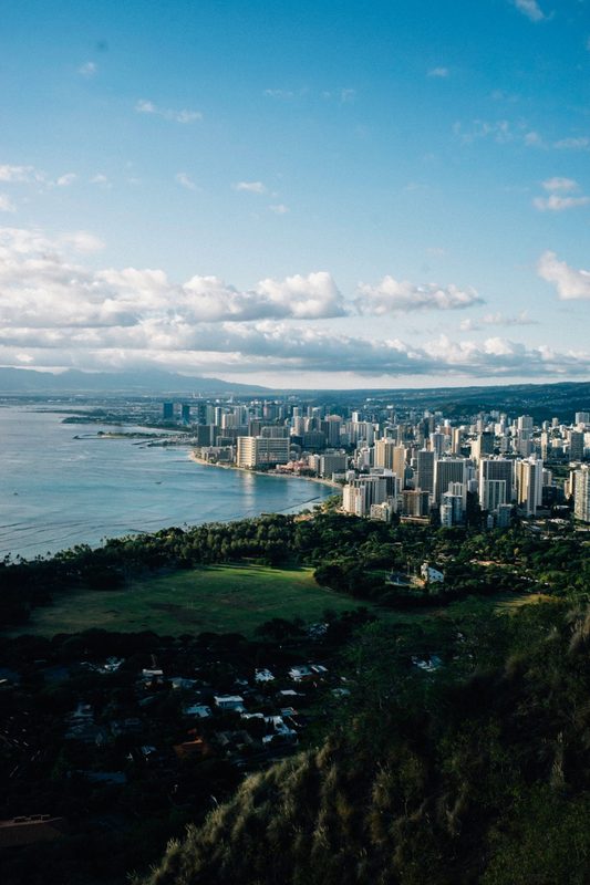 Honolulu apartment towers against a dramatic sunset sky with mountains behind
