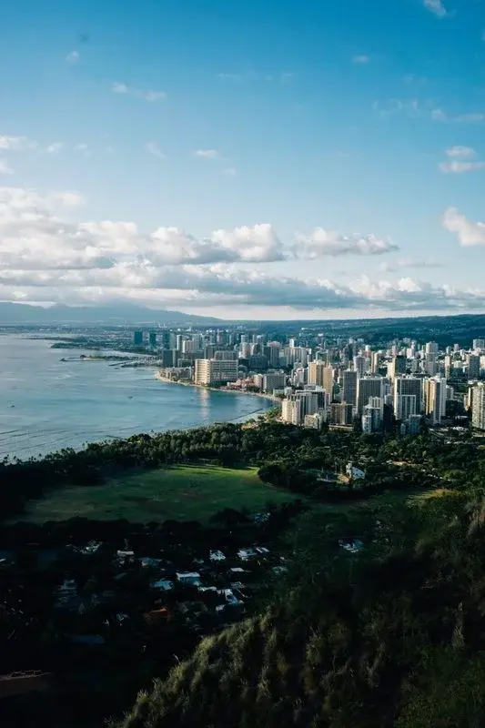Honolulu apartment towers against a dramatic sunset sky with mountains behind