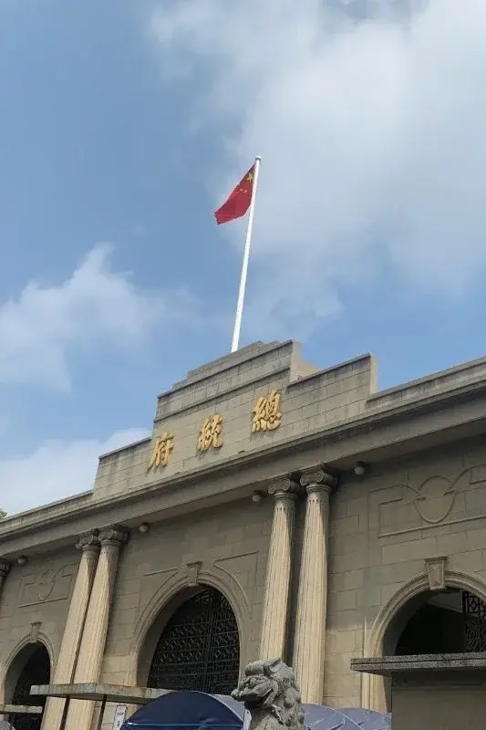The former Presidential Palace of the Republic of China in Nanjing, its stone facade reading '总统府' beneath a Chinese national flag