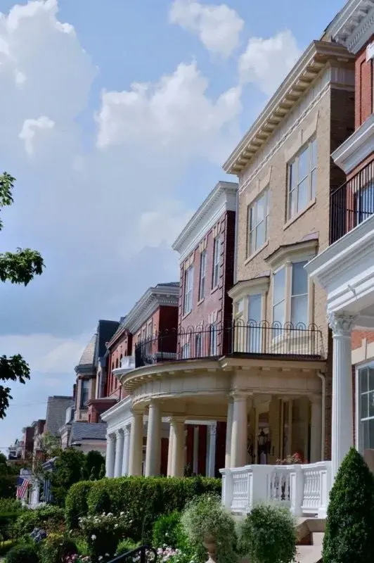 A row of ornate Victorian and Colonial Revival townhouses with columned porches in Richmond's historic Fan District