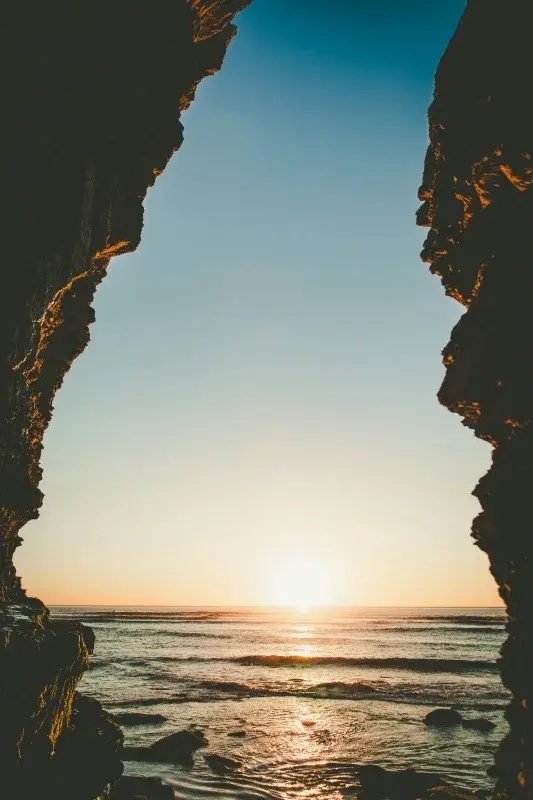 Sunset over the Pacific Ocean framed between coastal cliffs near San Diego