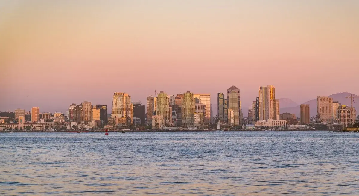San Diego's downtown skyline and harbor at sunset, sailboats on the water