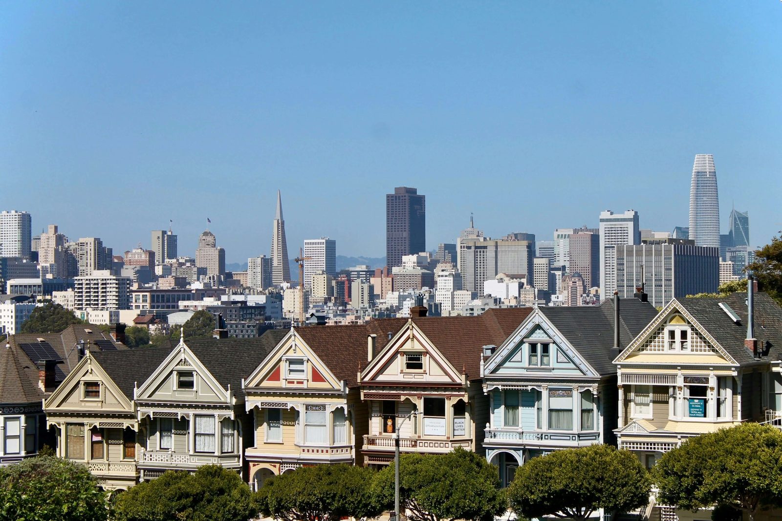 A row of San Francisco Victorian houses in front of the downtown skyscrapers