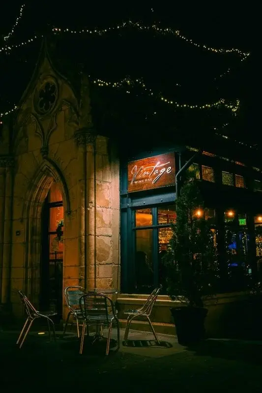 Vintage Wine Bar in downtown San Jose at night, housed in a Gothic stone archway with string lights