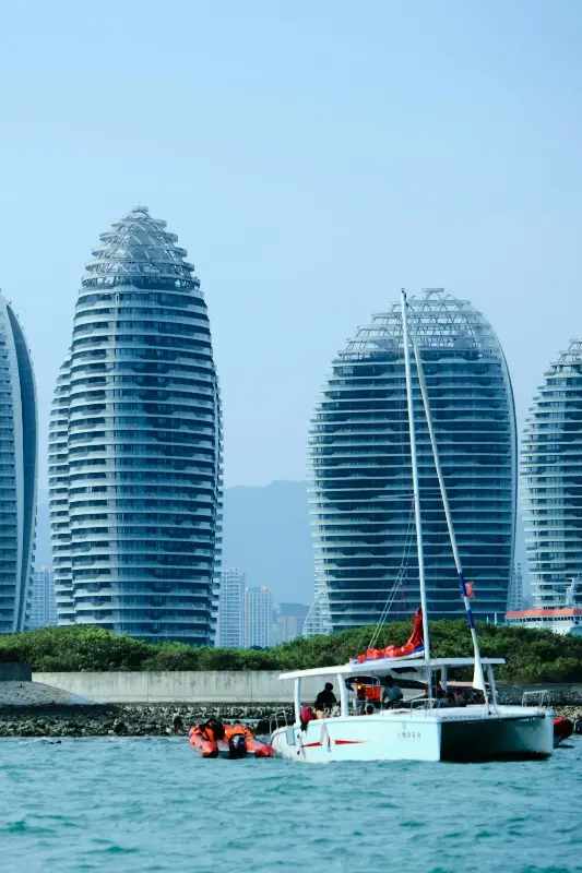 Sanya Phoenix Island cruise port, catamarans and leisure boats near iconic egg‑shaped buildings