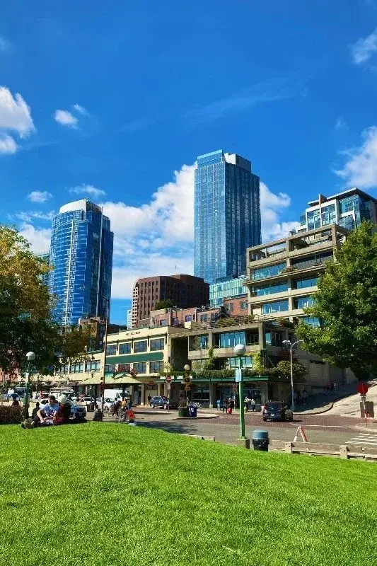 Seattle apartment and office towers seen from a waterfront park lawn