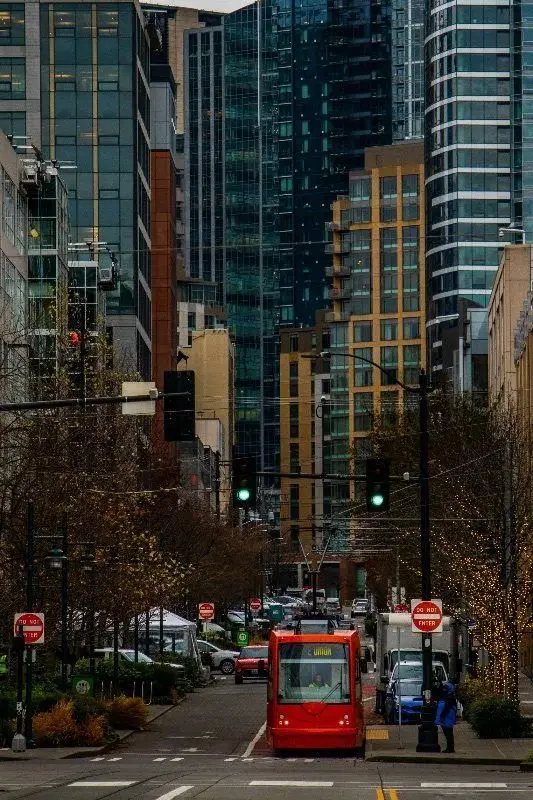 Seattle's South Lake Union streetcar running down a downtown street between office towers
