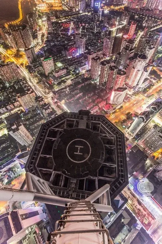 Looking straight down from the top of a Shenzhen skyscraper at night, the illuminated city grid below