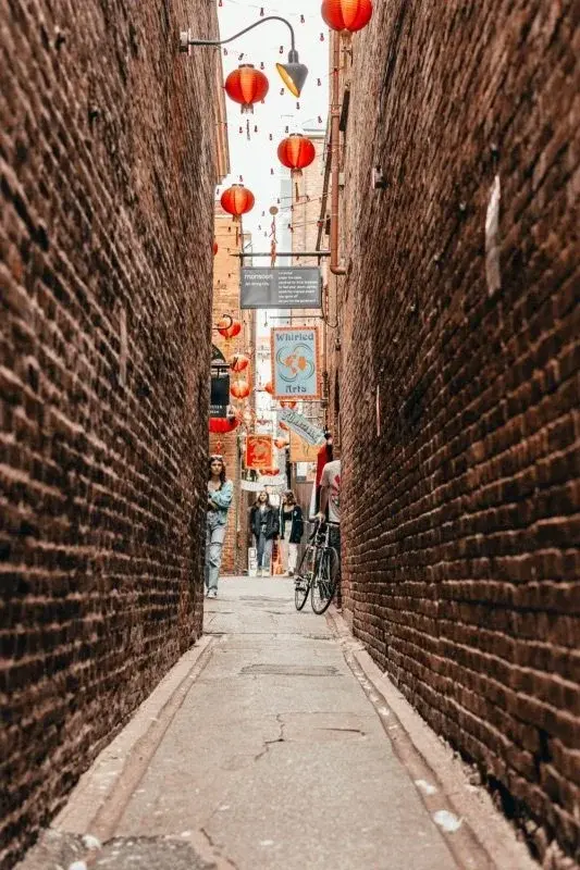Fan Tan Alley in Victoria's Chinatown, a narrow brick passage strung with red lanterns