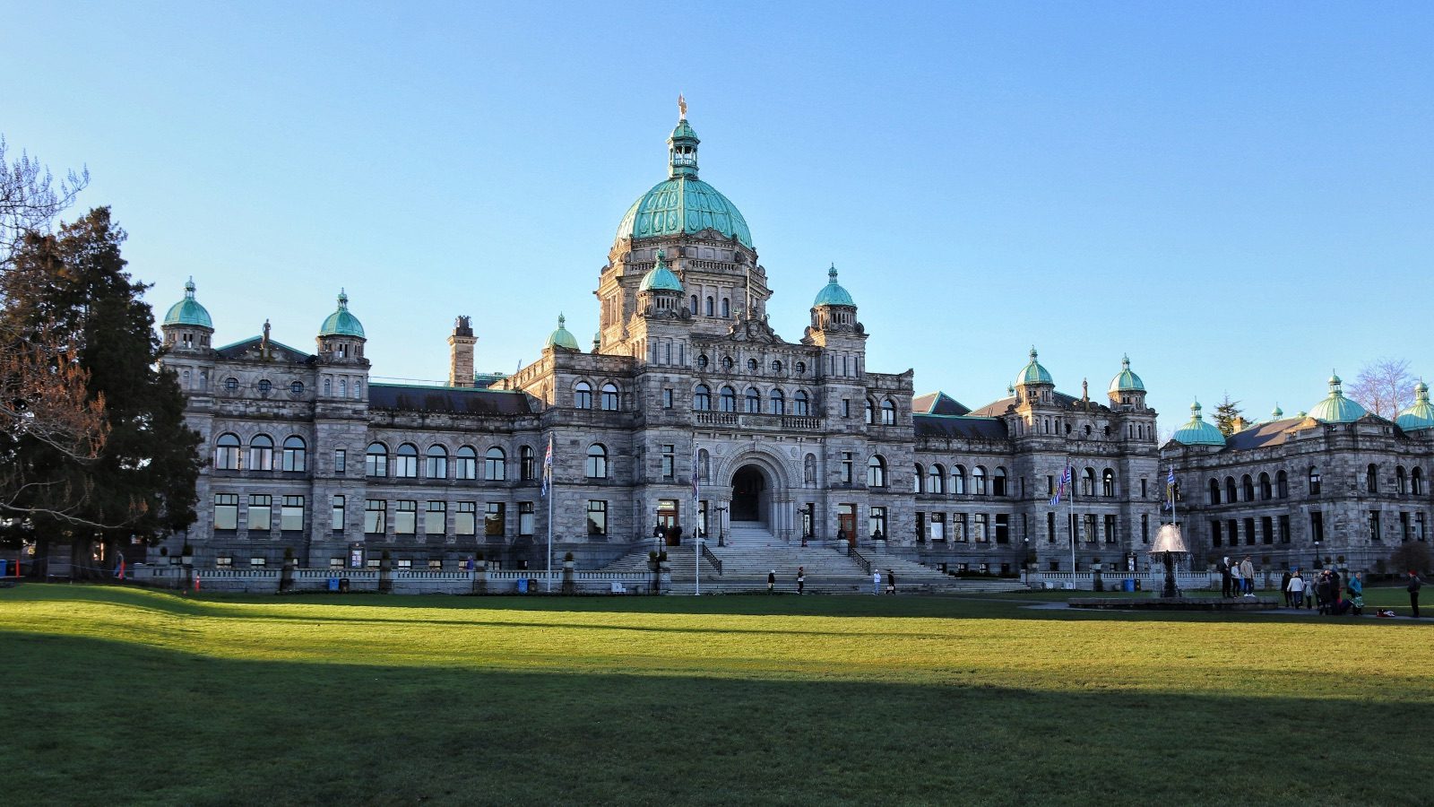 The British Columbia Parliament Buildings in Victoria, a Neo-baroque stone building with green copper domes, seen across a lawn