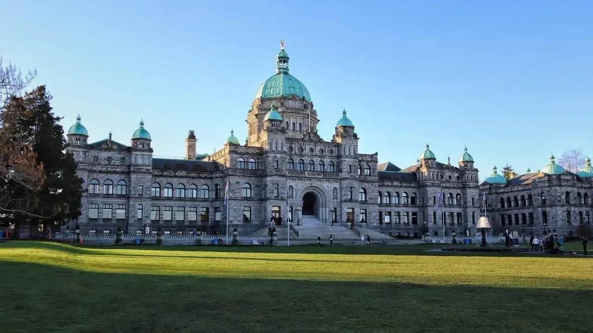 The British Columbia Parliament Buildings in Victoria, a Neo-baroque stone building with green copper domes, seen across a lawn