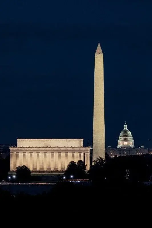 The Lincoln Memorial, Washington Monument, and Capitol dome lit at night along the National Mall