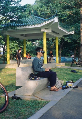 A young man using a VR headset in a Shenzhen park