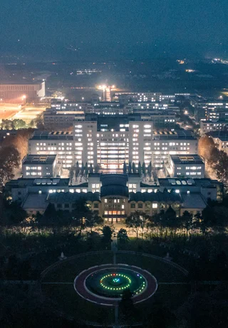 A floodlit university main-building complex at night in Shaanxi
