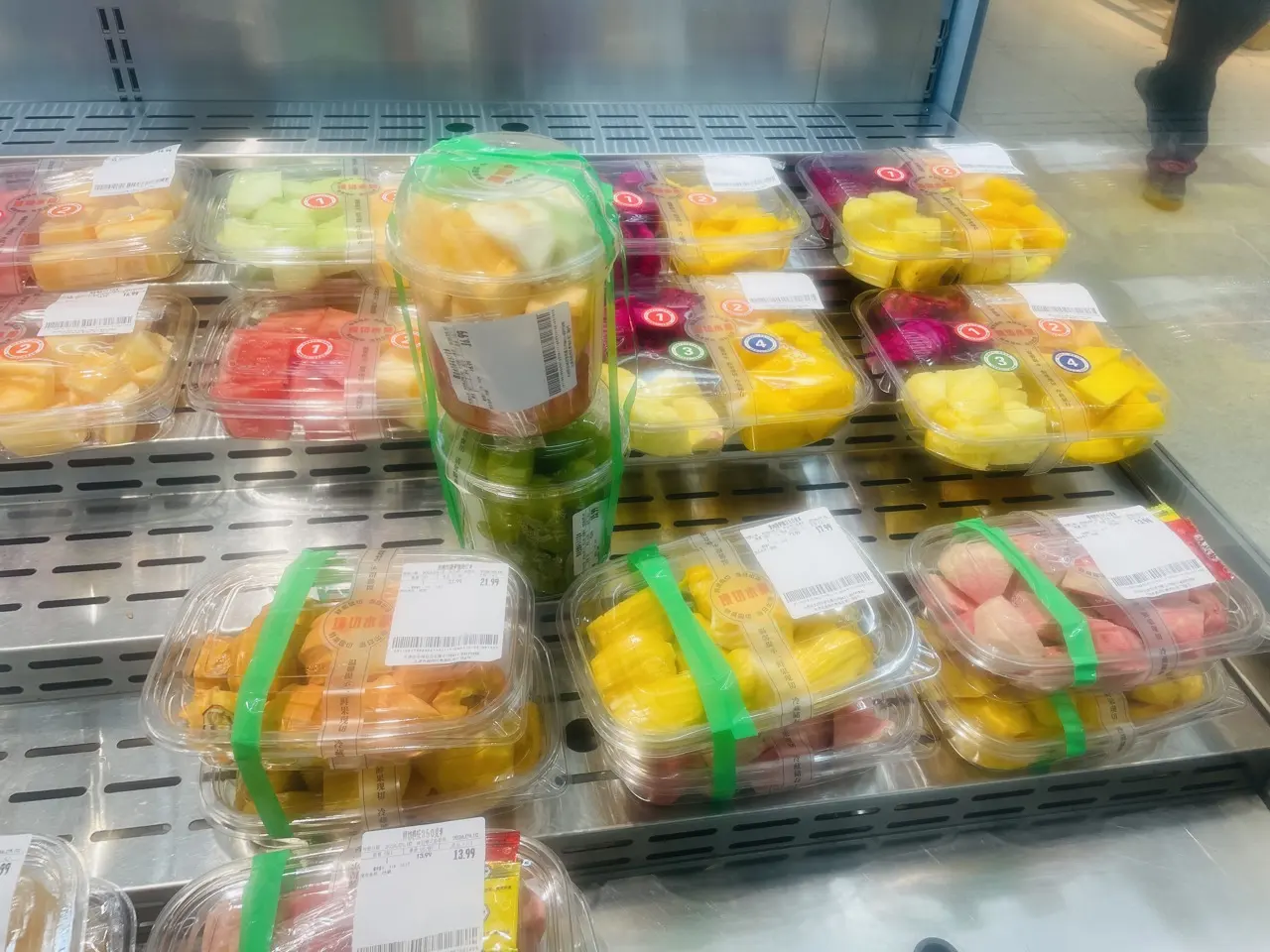 Supermarket chiller cabinet in China filled with sealed pre-packed fruit cups, each with a printed price label