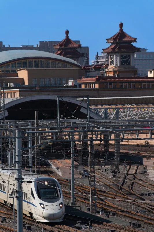 Beijing Railway Station with traditional roofs and modern high-speed trains