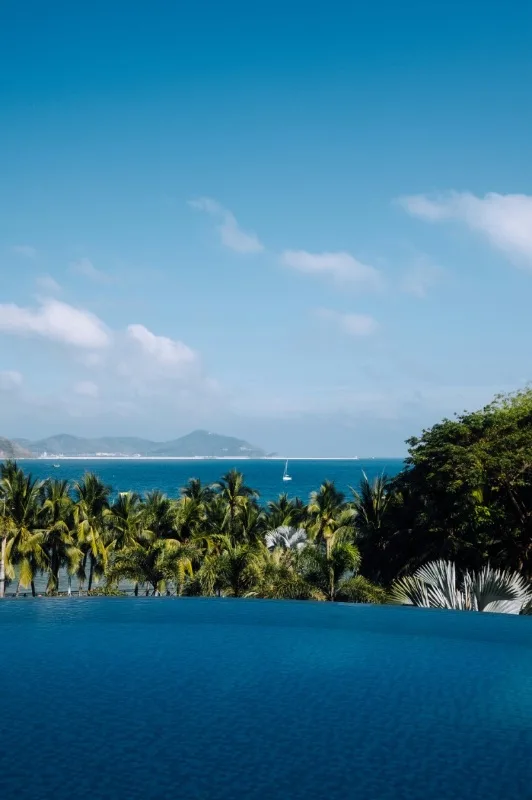 Sanya's tropical beach with a luxury infinity pool and palm trees