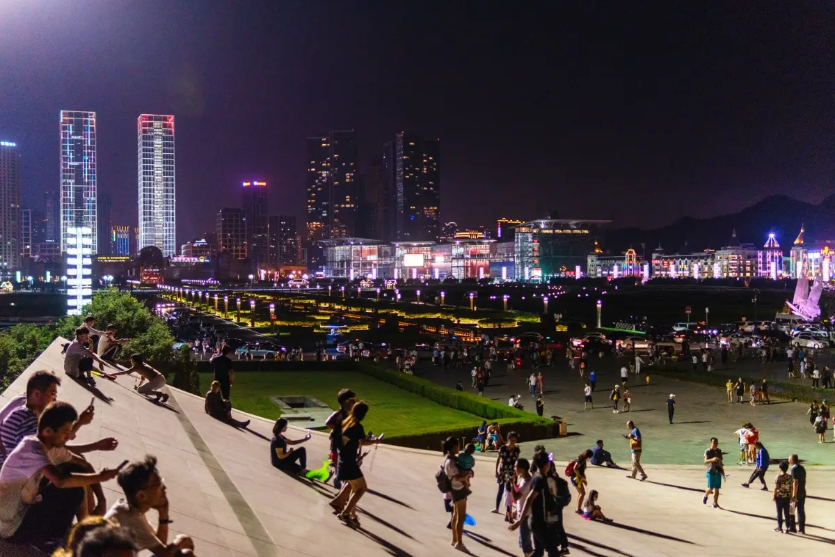 Crowds gathering at Dalian Xinghai Square on a summer night to escape the heat.