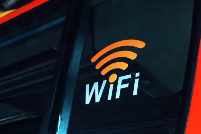An orange Wi-Fi symbol and lettering displayed on a dark window