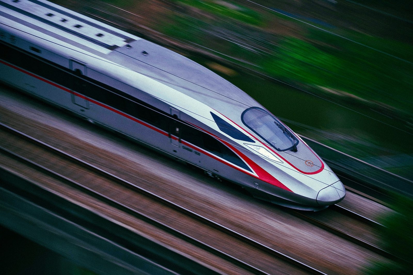 Aerial close-up of a Fuxing-class high-speed train in motion, motion blur emphasizing its speed