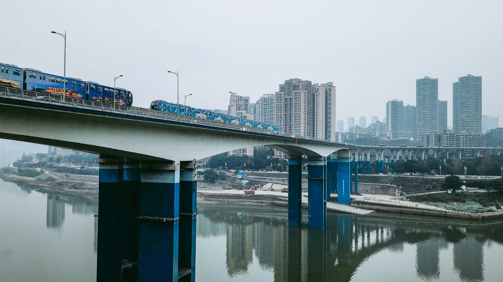 Elevated Chongqing rail transit train crossing a bridge over the river