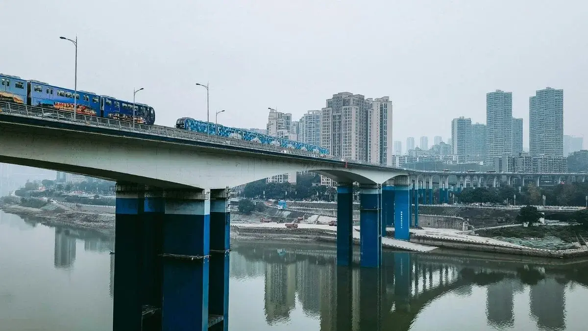 Elevated Chongqing rail transit train crossing a bridge over the river